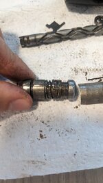 The spring, washers, and retaining wire (between the washers). Compressing the spring left in this image disengages the retaining wire (between the washers) releasing the bit. 